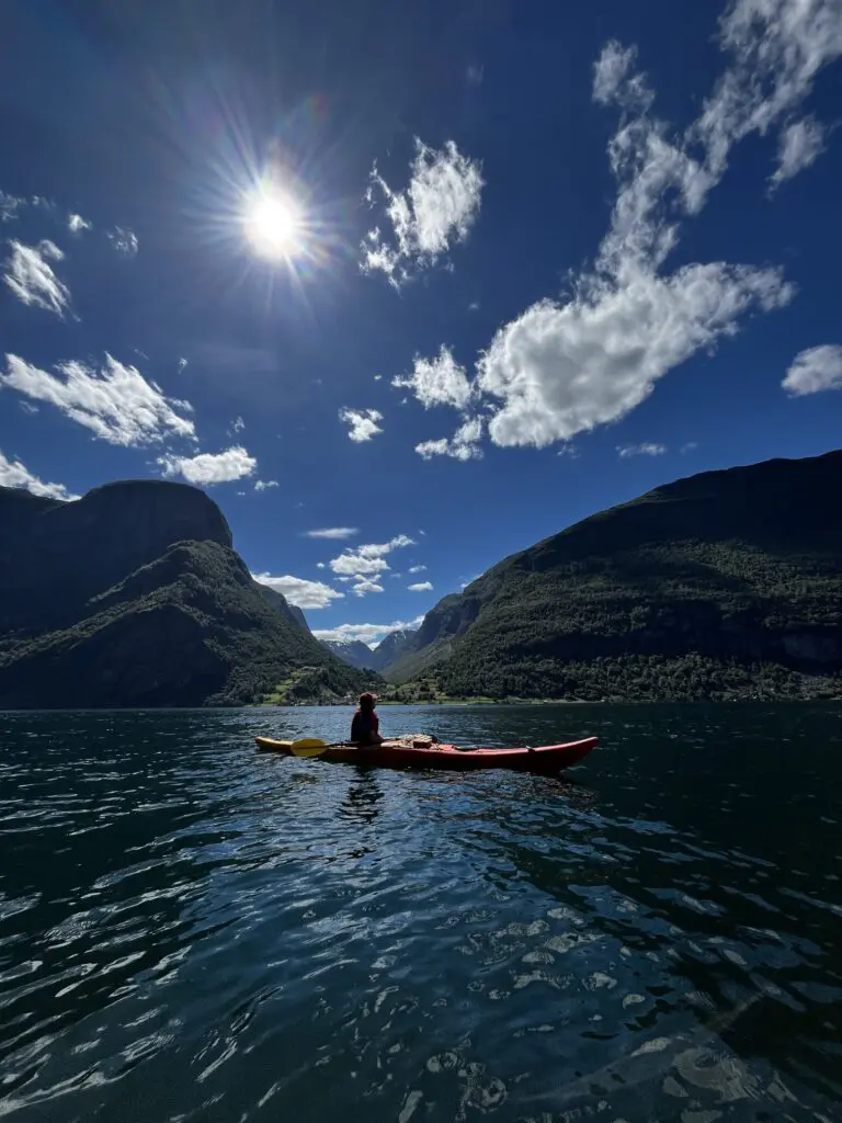 Person kayaking in front of Undredal, Norway