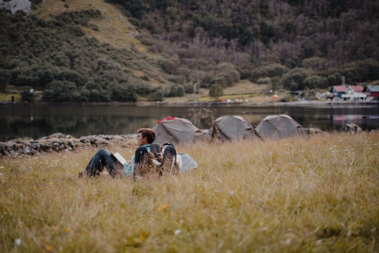 2 men chilling in gras field with tents