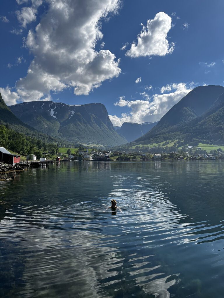 woman swimming in the water in front of Fresvik, Norway